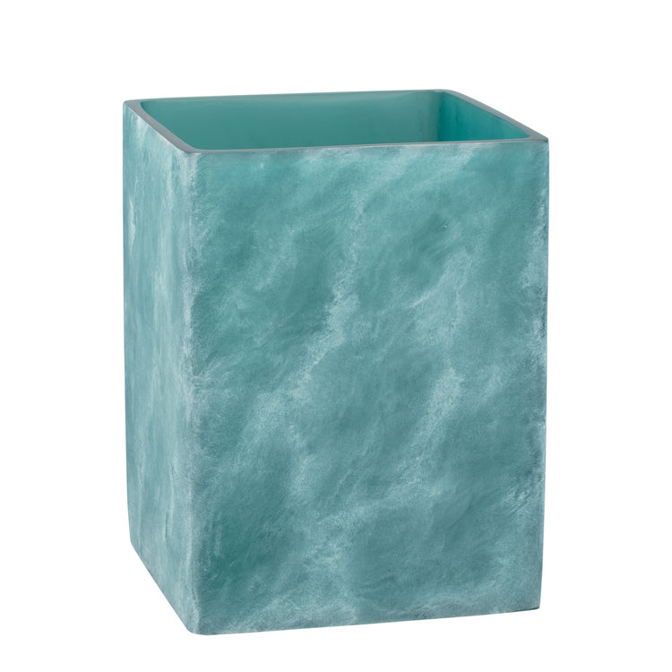 Turquoise | A square-shaped teal resin wastebasket with a textured, ocean wave-like pattern, shown on a plain white background.