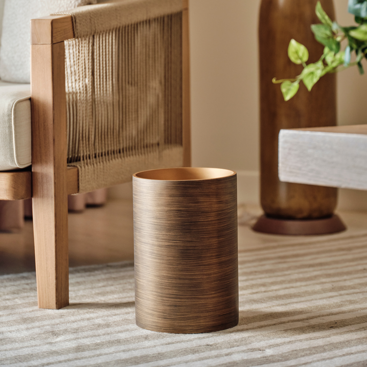 Gold | 9qt wastebasket sitting on a hotel room floor.
