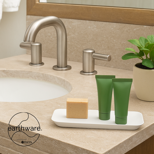 White | Bathroom counter with green tubes, soap, and a plant on a white tray, featuring the earthware brand.