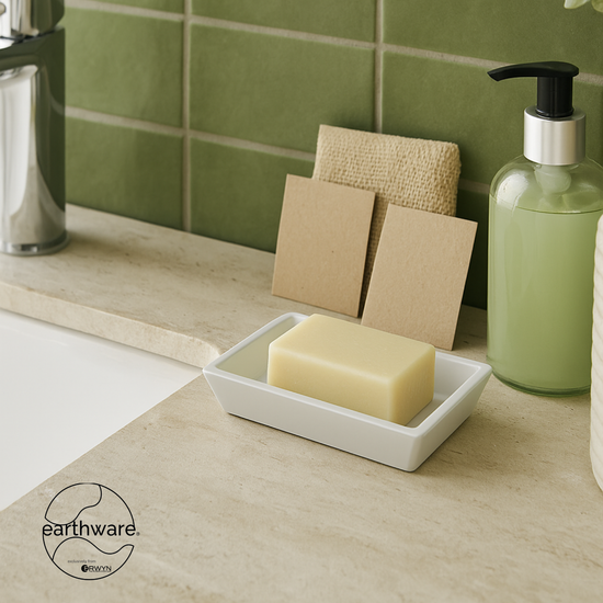 White | Soap dish on a bathroom countertop next to the sink holding a bar of soap
